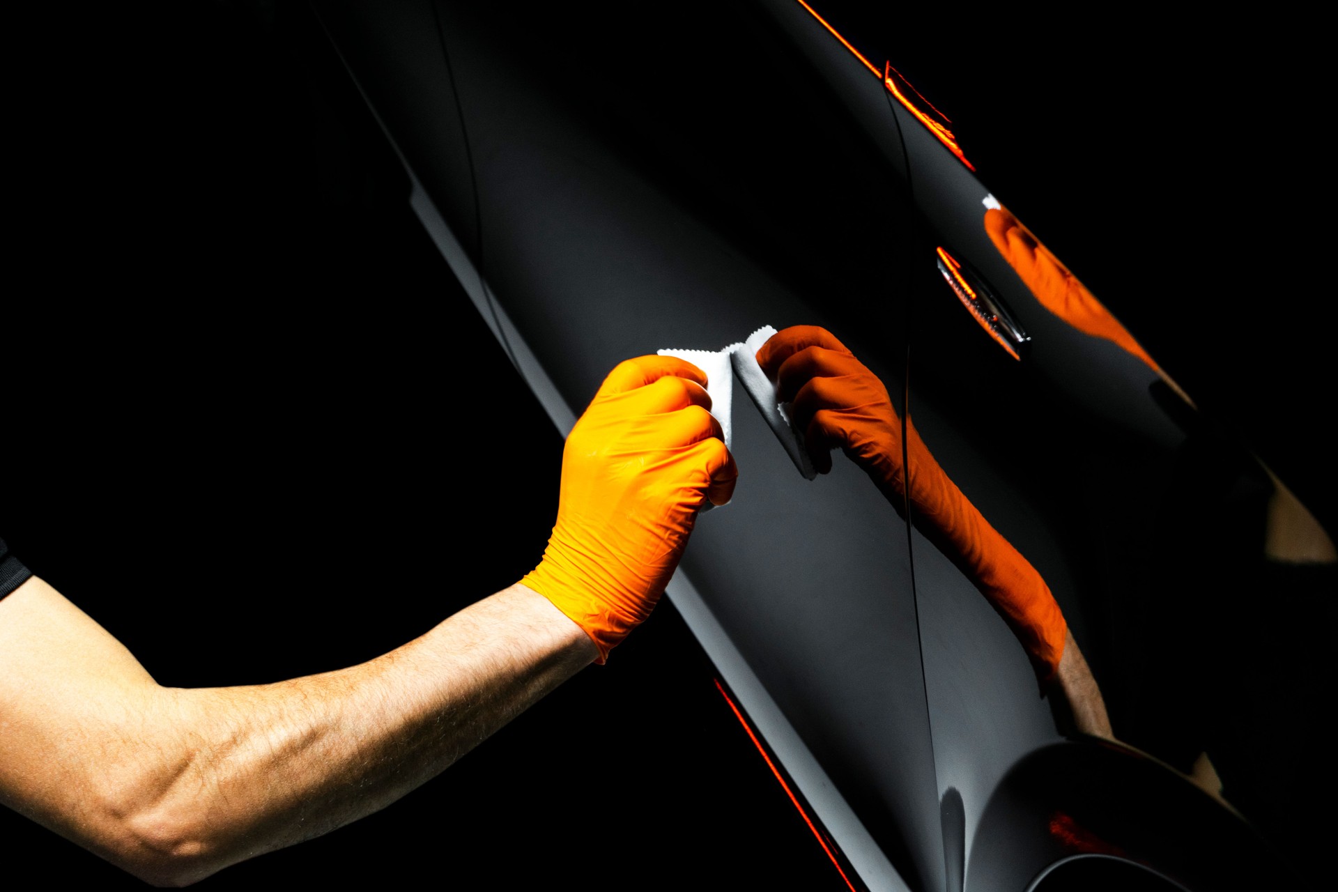 Voiture vernis cire travailleur mains voiture de polissage. Ponçage et polissage de véhicule avec céramique. Détailler de la voiture. L’homme tient un polissoir dans la main et polit la voiture avec nano céramique. Outils de polissage